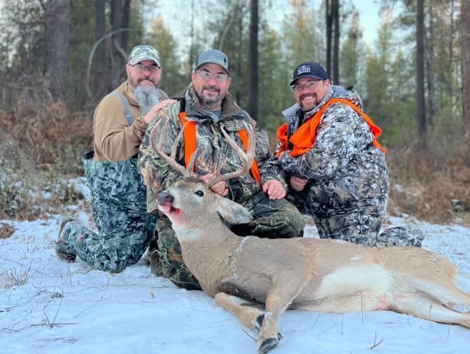 James with two hunting partners and a buck in the snow